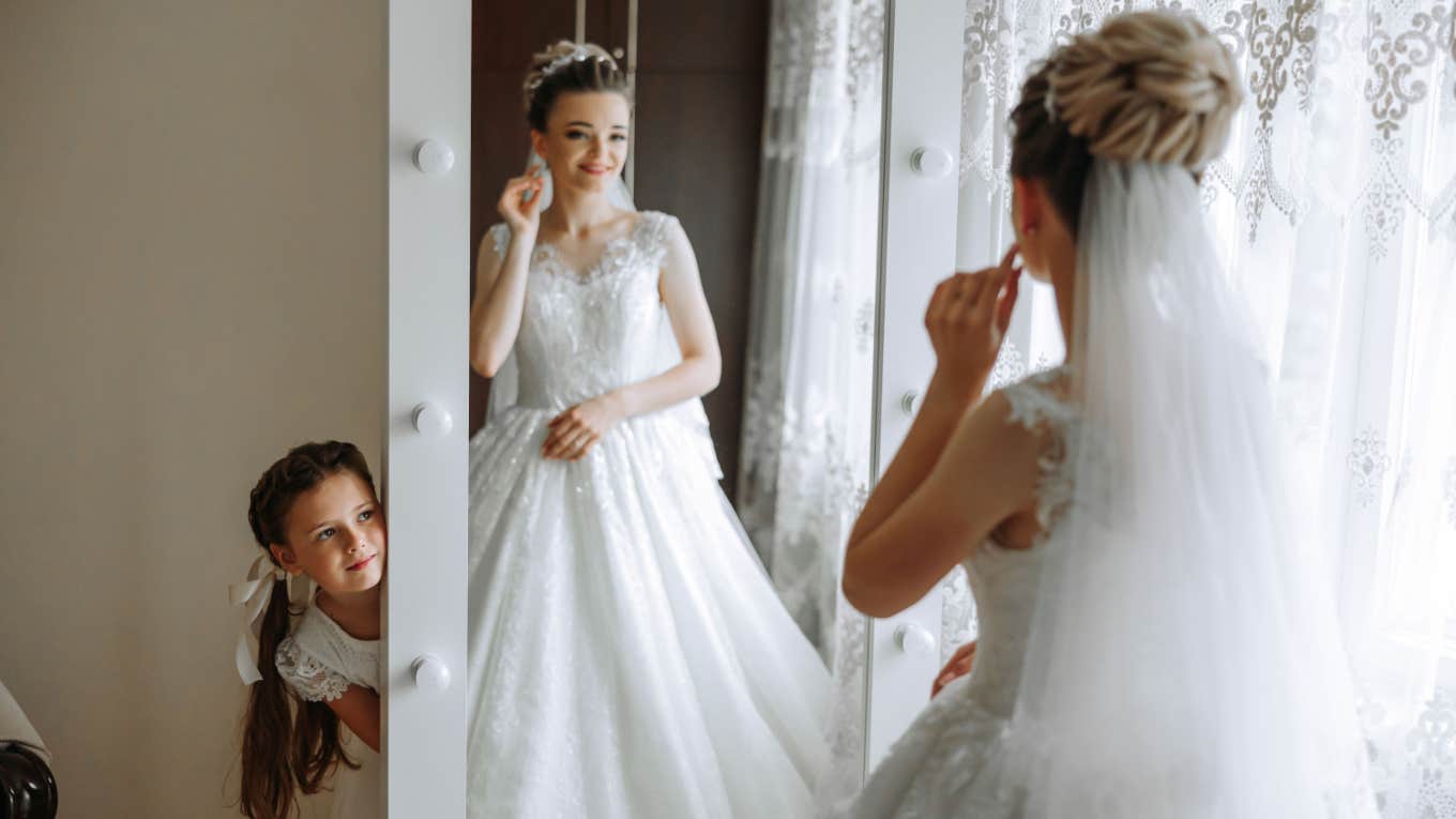 bride gets ready for wedding with little sister