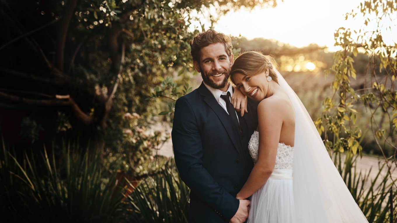 bride and groom smile and pose together outside during wedding