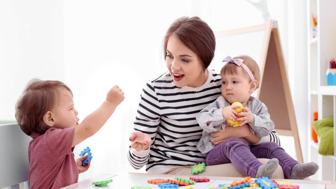 teenage girl babysits and plays with two young kids 