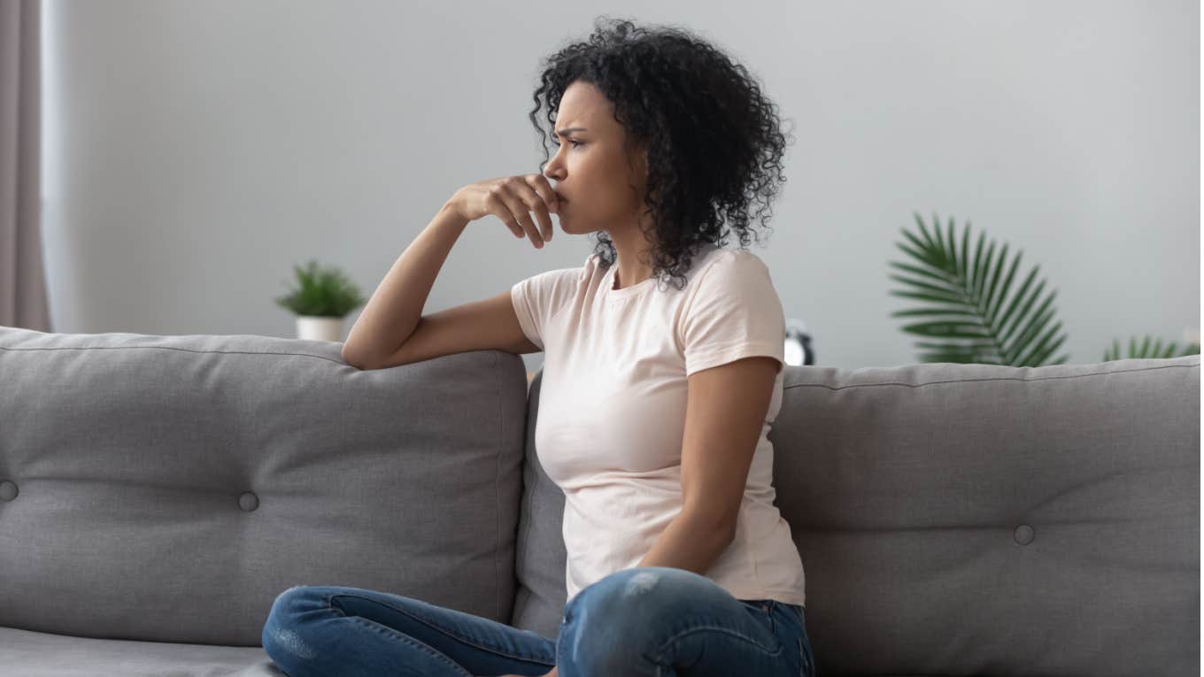 woman anxiously feeling guilty while resting on couch at home