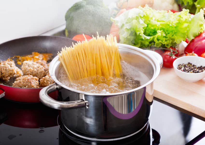 boiling spaghetti noodles and cooking sauce in kitchen