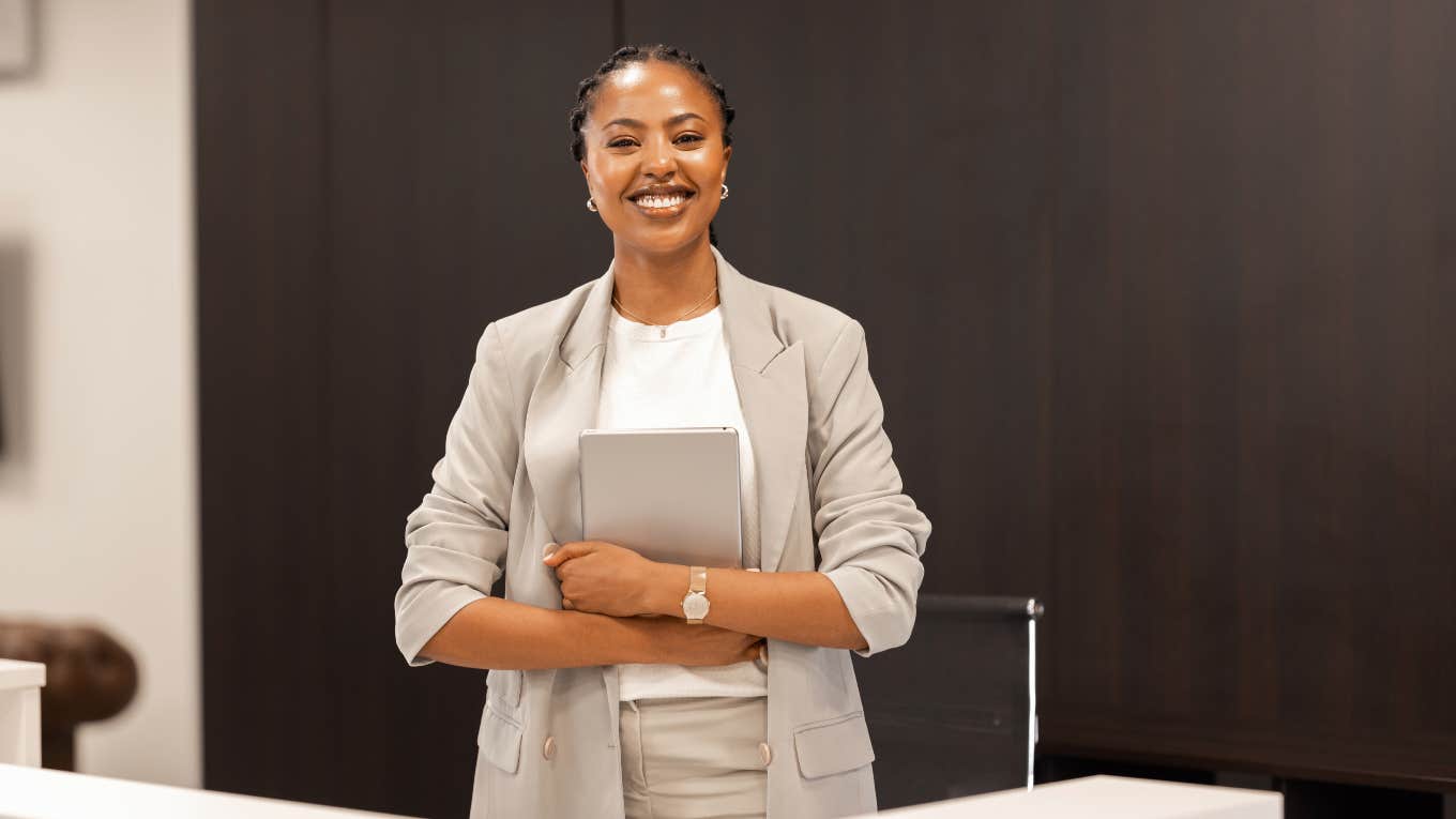 receptionist standing behind desk holding tablet