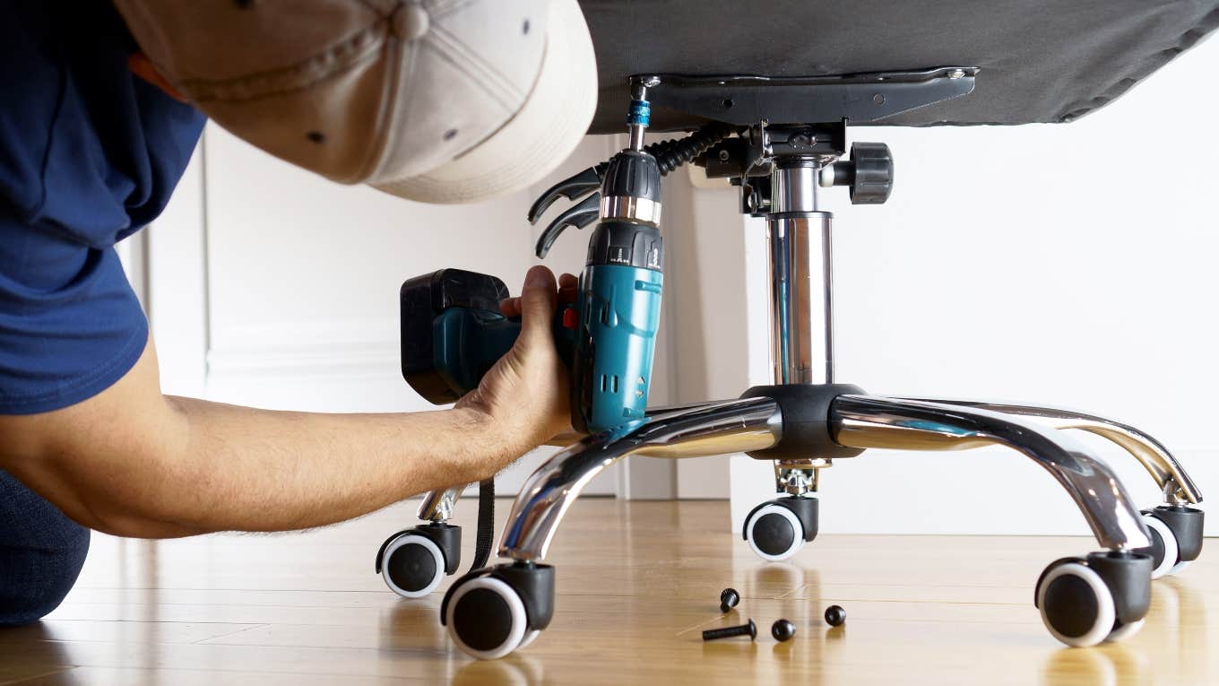 man adjusting office chair with screwdriver