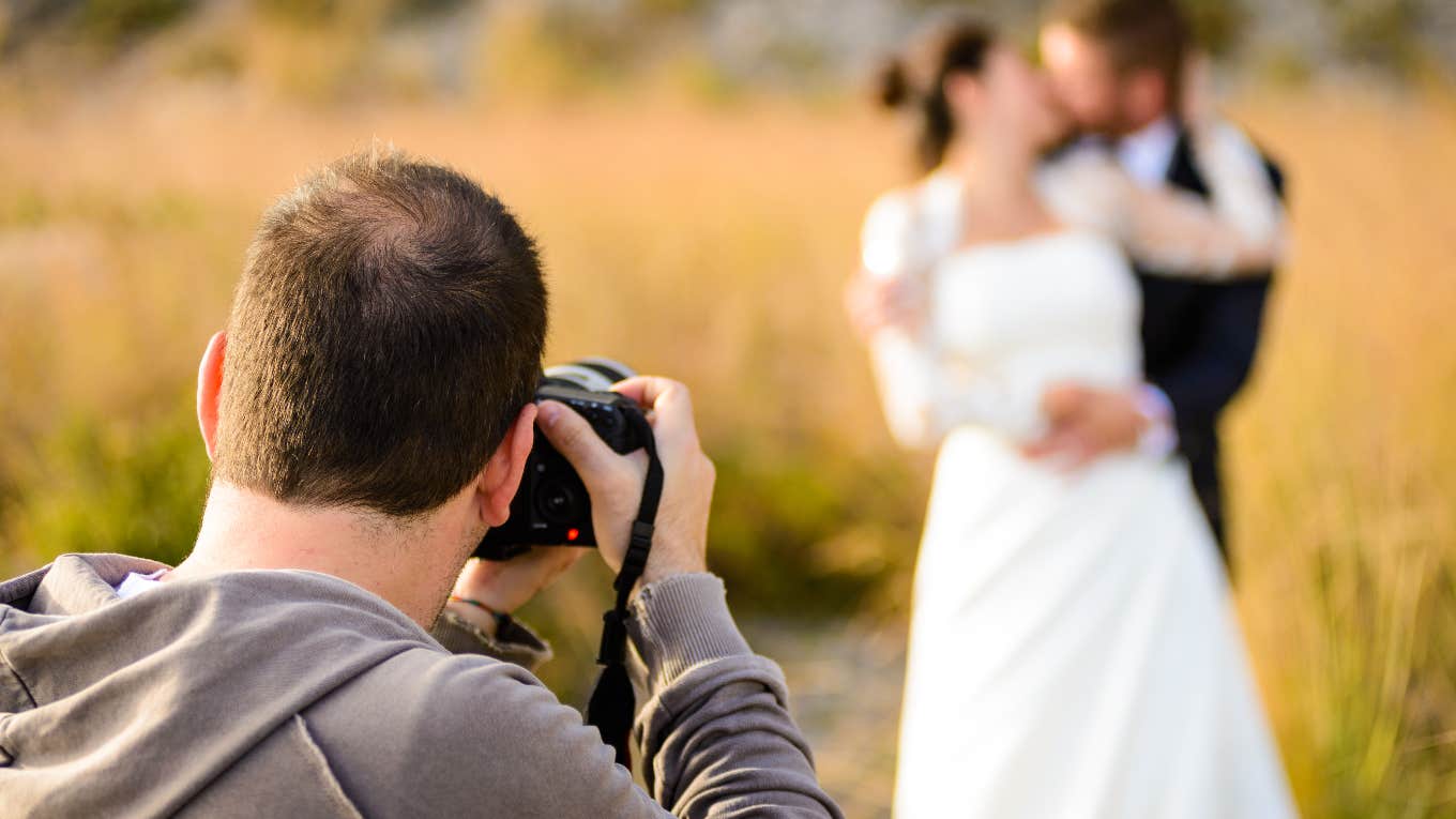 Wedding photographer taking photos of bride and groom