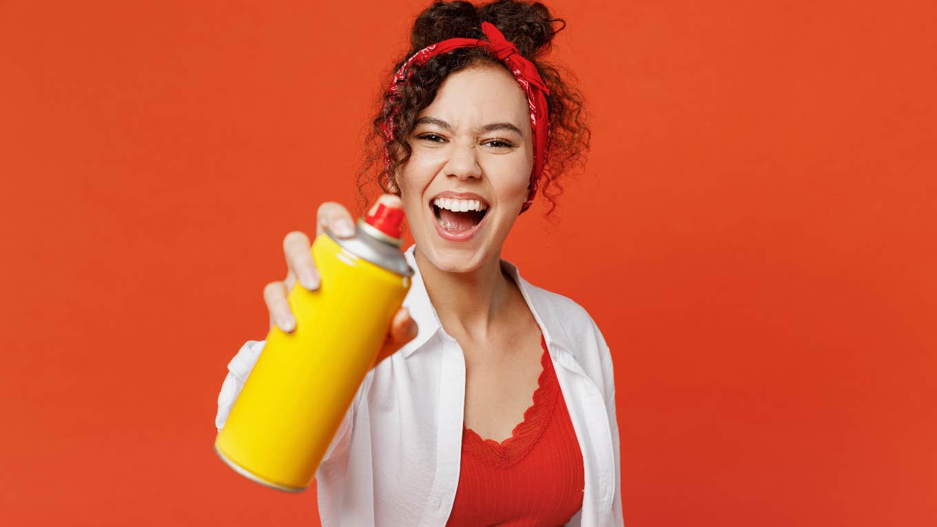 woman holding up spray bottle screaming