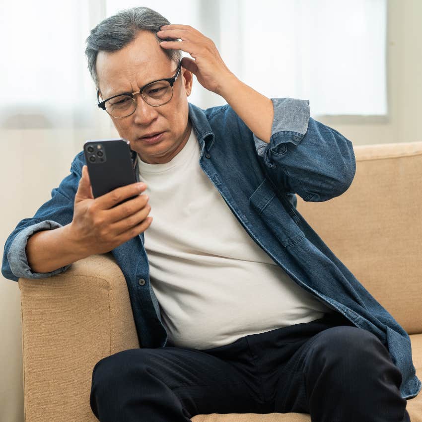 Older man looking confused at a new scam on his phone. 