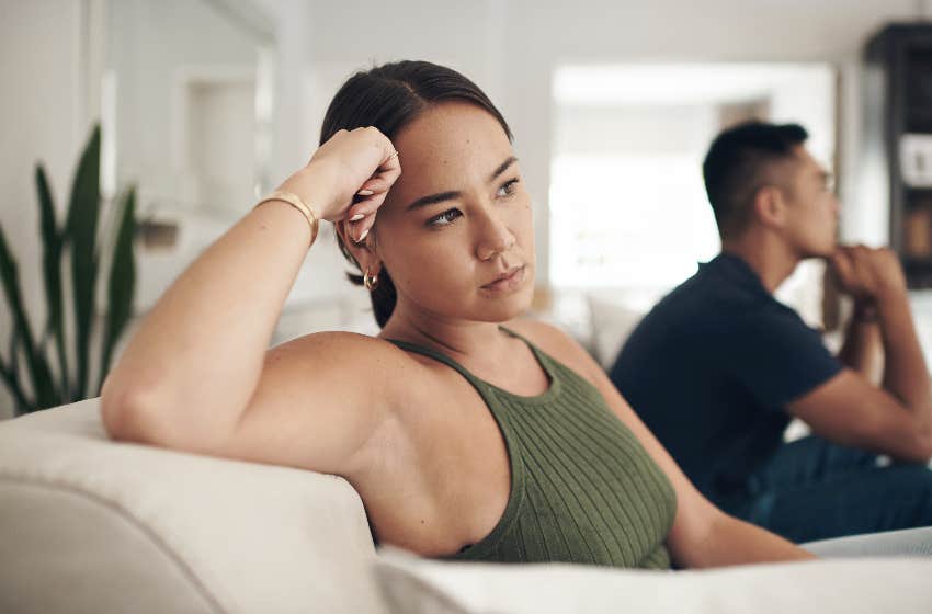 woman propping her head up with her hand while sitting on couch