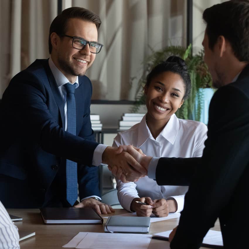 Narcissistic boss shaking hands with employee.