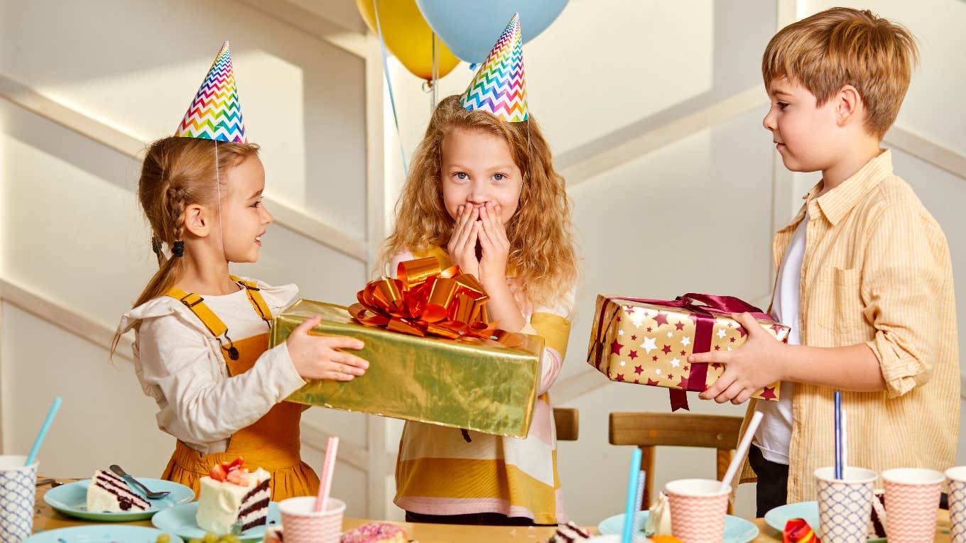 Little girl getting gifts at birthday party