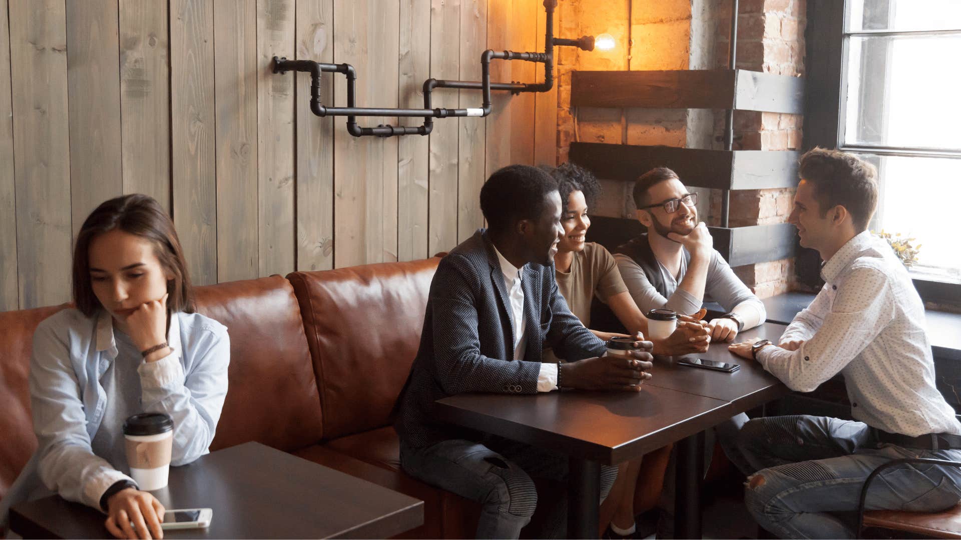 woman sitting by herself near coworkers