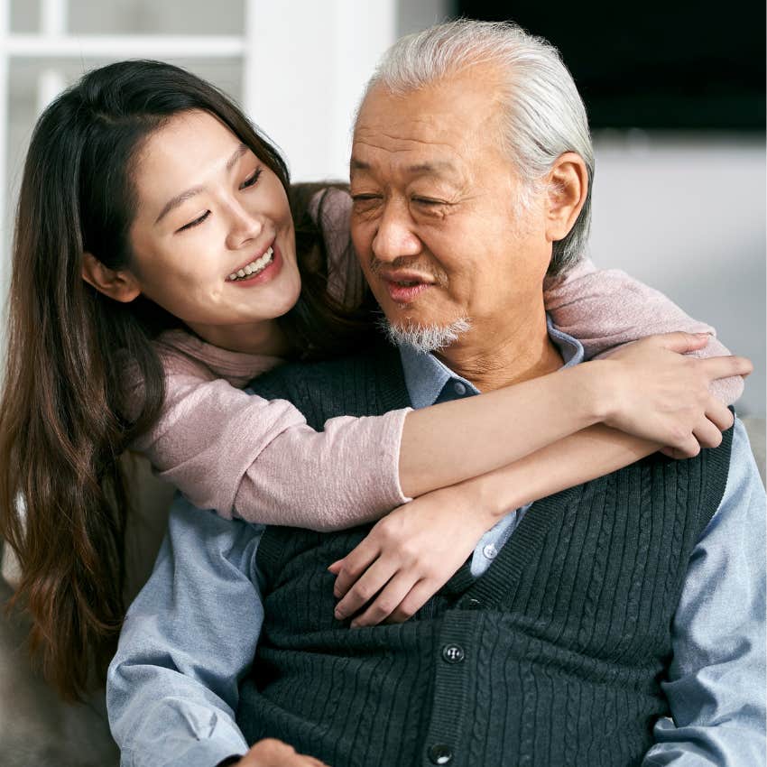 Dad and adult daughter hugging. 