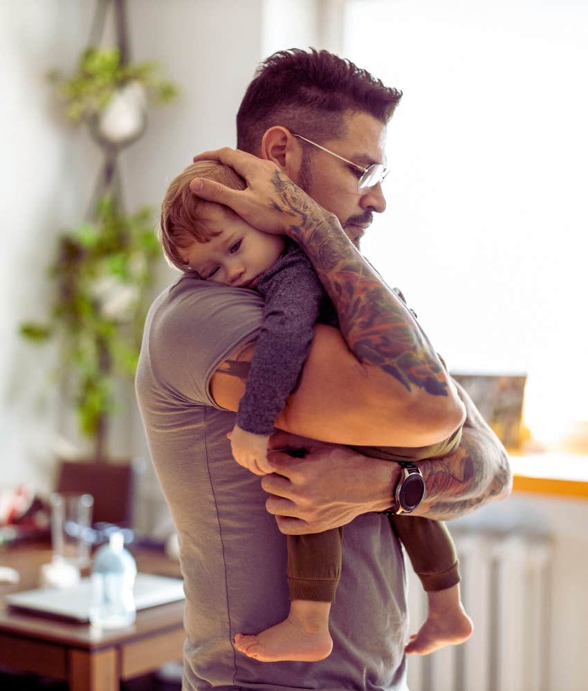 Dad holding and comforting toddler son