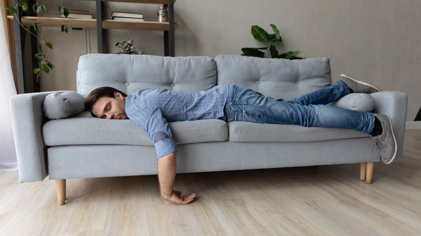 exhausted man taking a nap on a couch