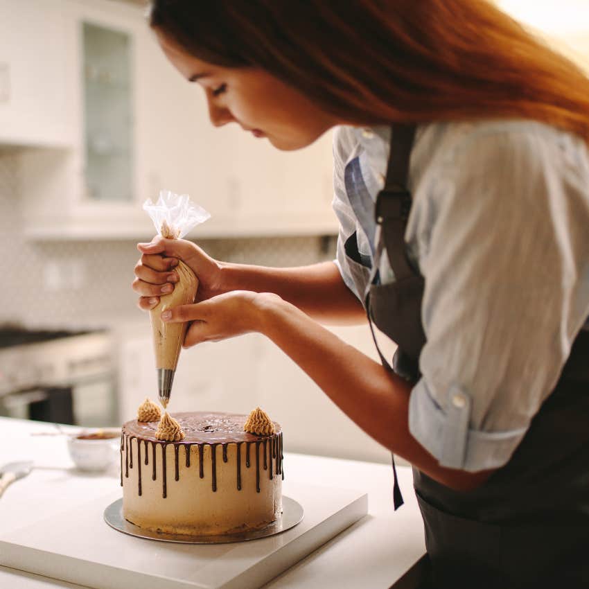 Woman decorating a cake in a bakery. 