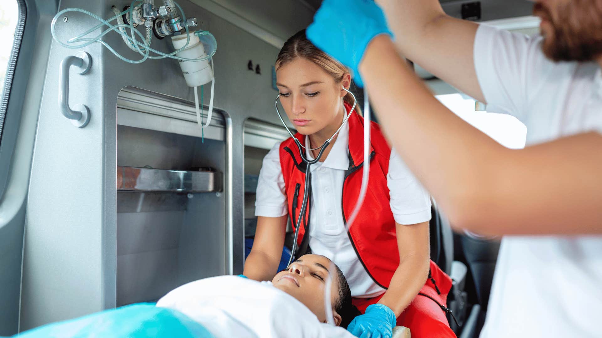 paramedic helping patient in ambulance 