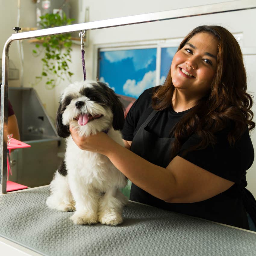 Dog groomer holding a disabled dog