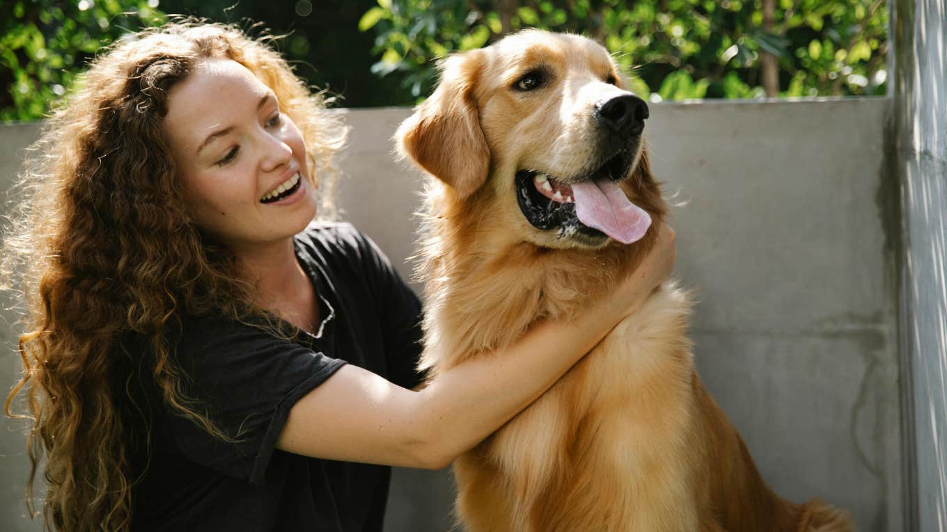 woman petting a golden retriever