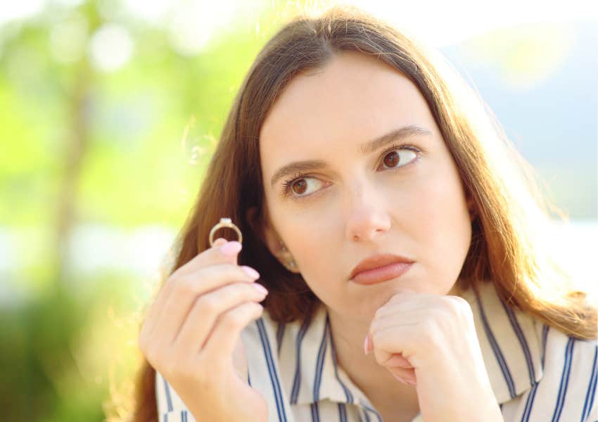 doubtful fiance holds wedding ring reconsidering marriage