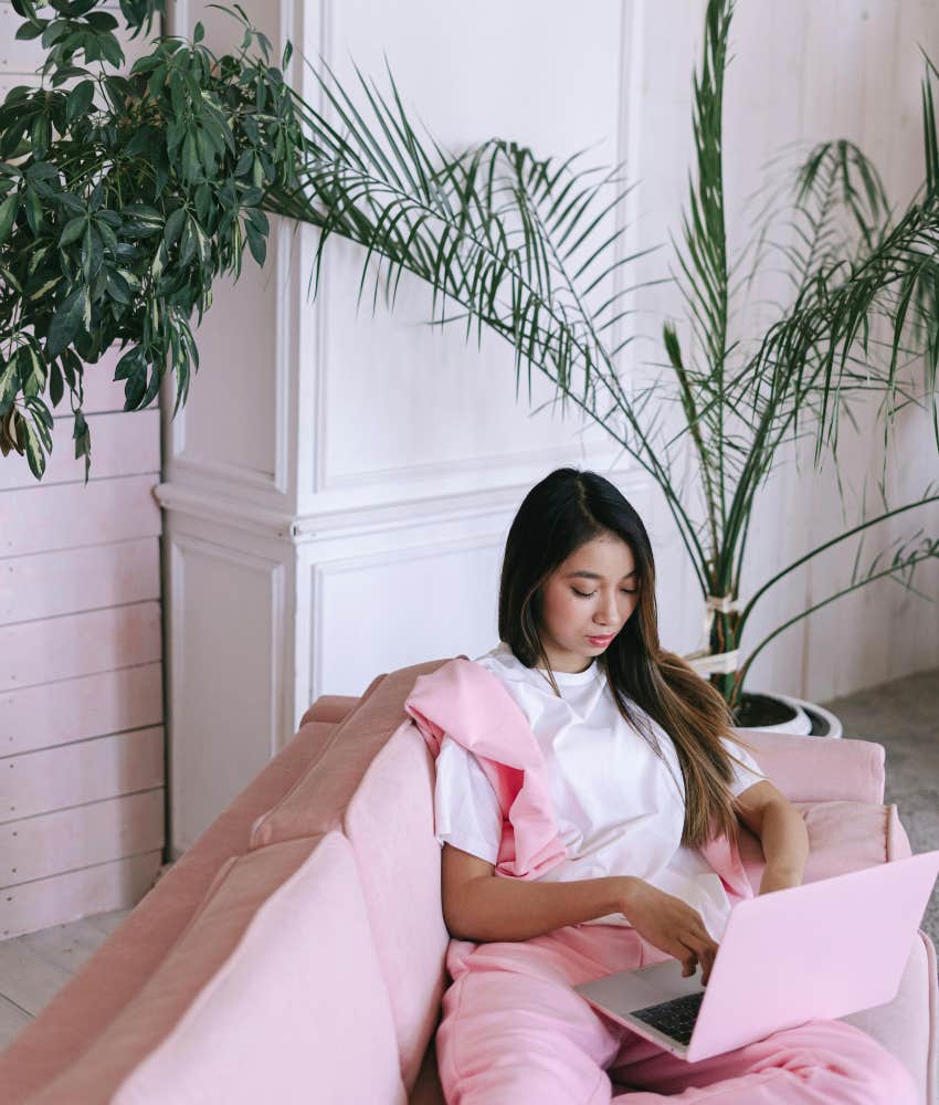 woman sitting on couch using laptop