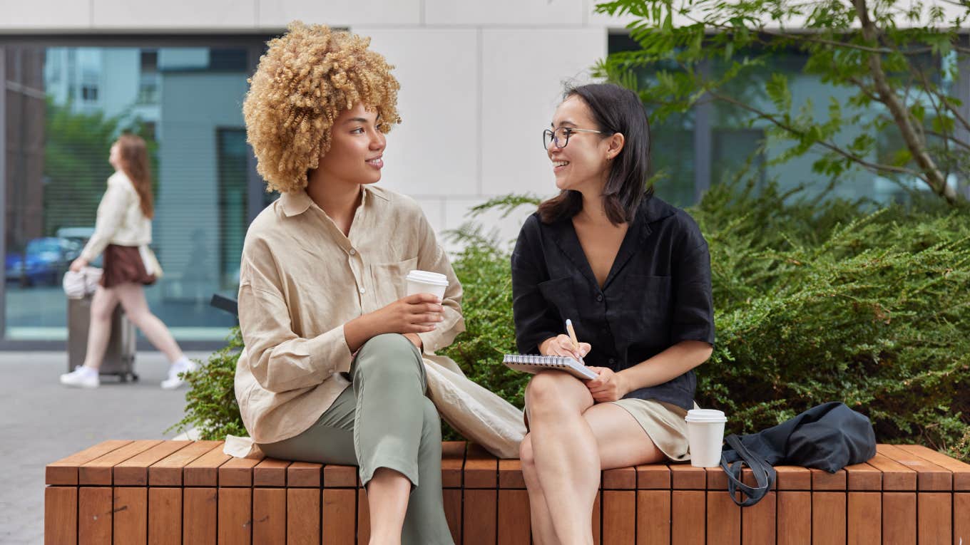 two women having conversation while sitting outside