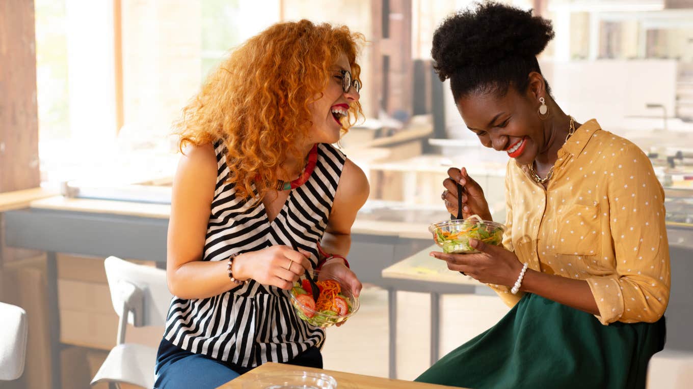 Two coworkers eat doordash at work.