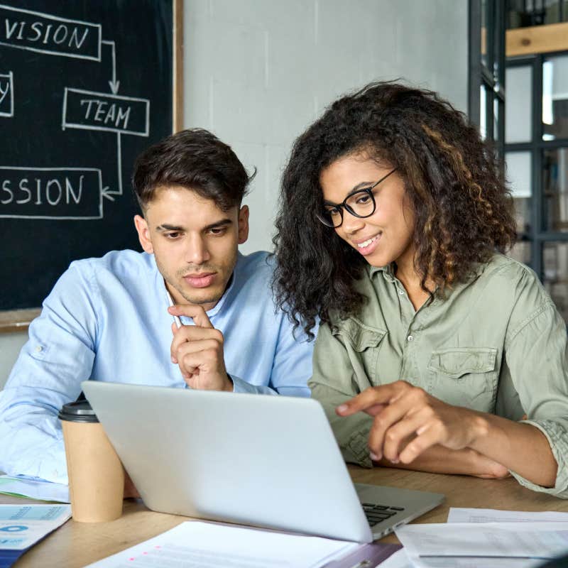 employees looking at laptop and working in office