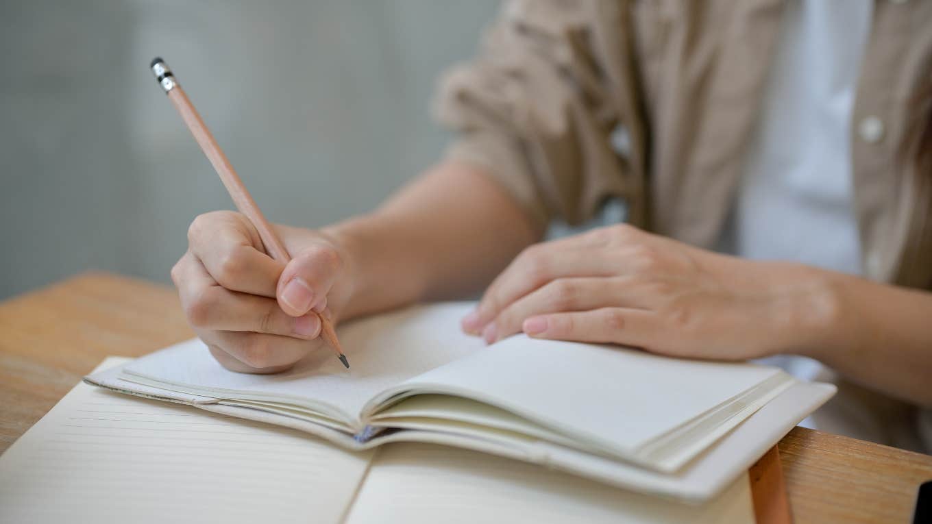 person writing in notebook