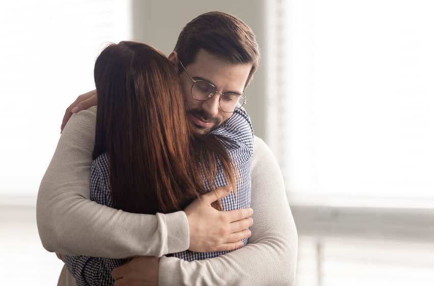 man hugging woman while smiling