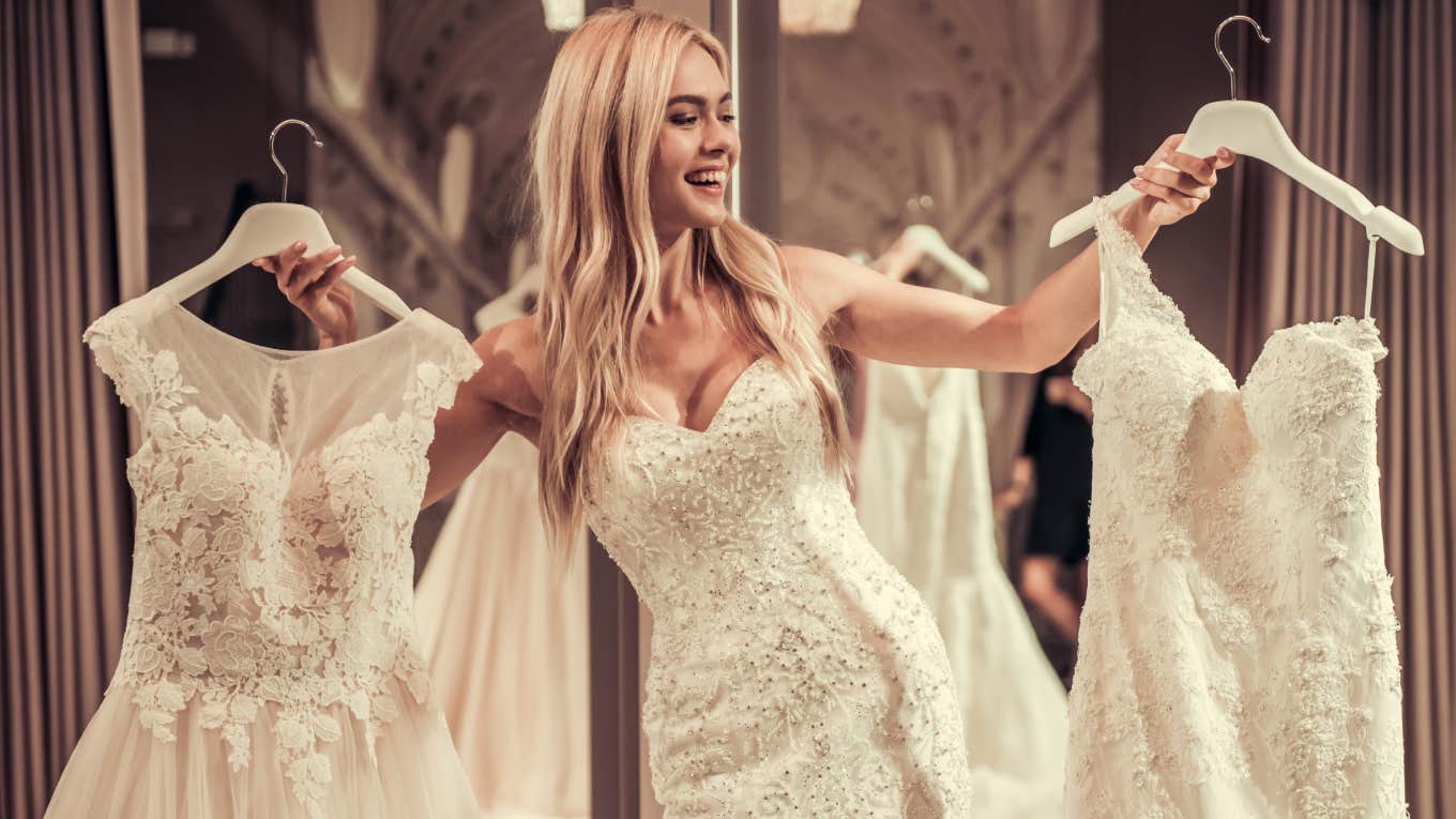 young bride smiling while trying on wedding dress in modern wedding salon