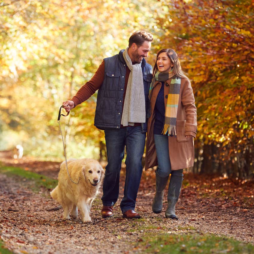 Happy married couple walking their dog