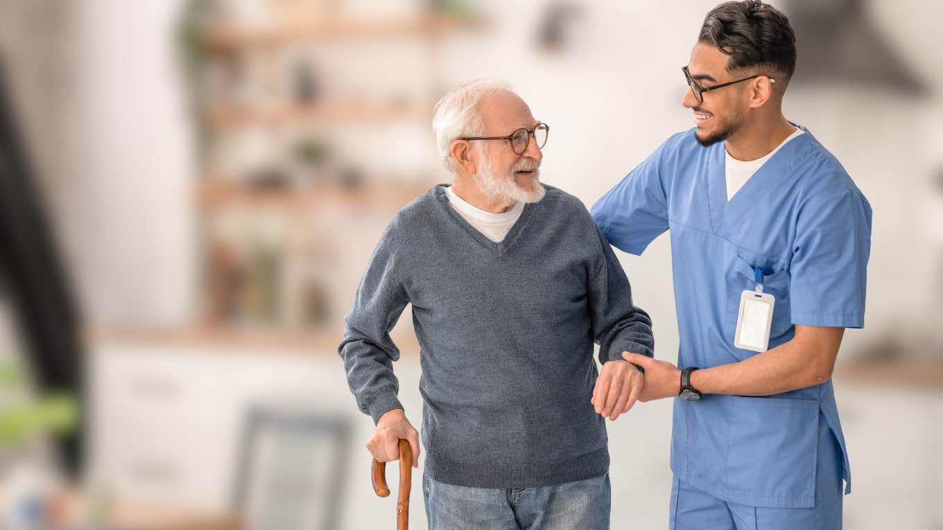 Healthcare worker helping a boomer walk in his home. 