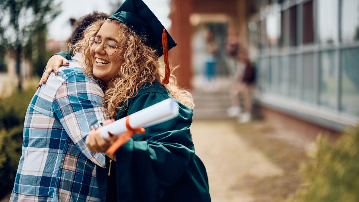 Happy student hugging her father after receiving diploma on graduation day at the university.