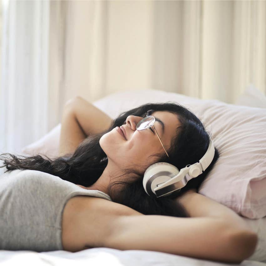 woman listening to music in bed