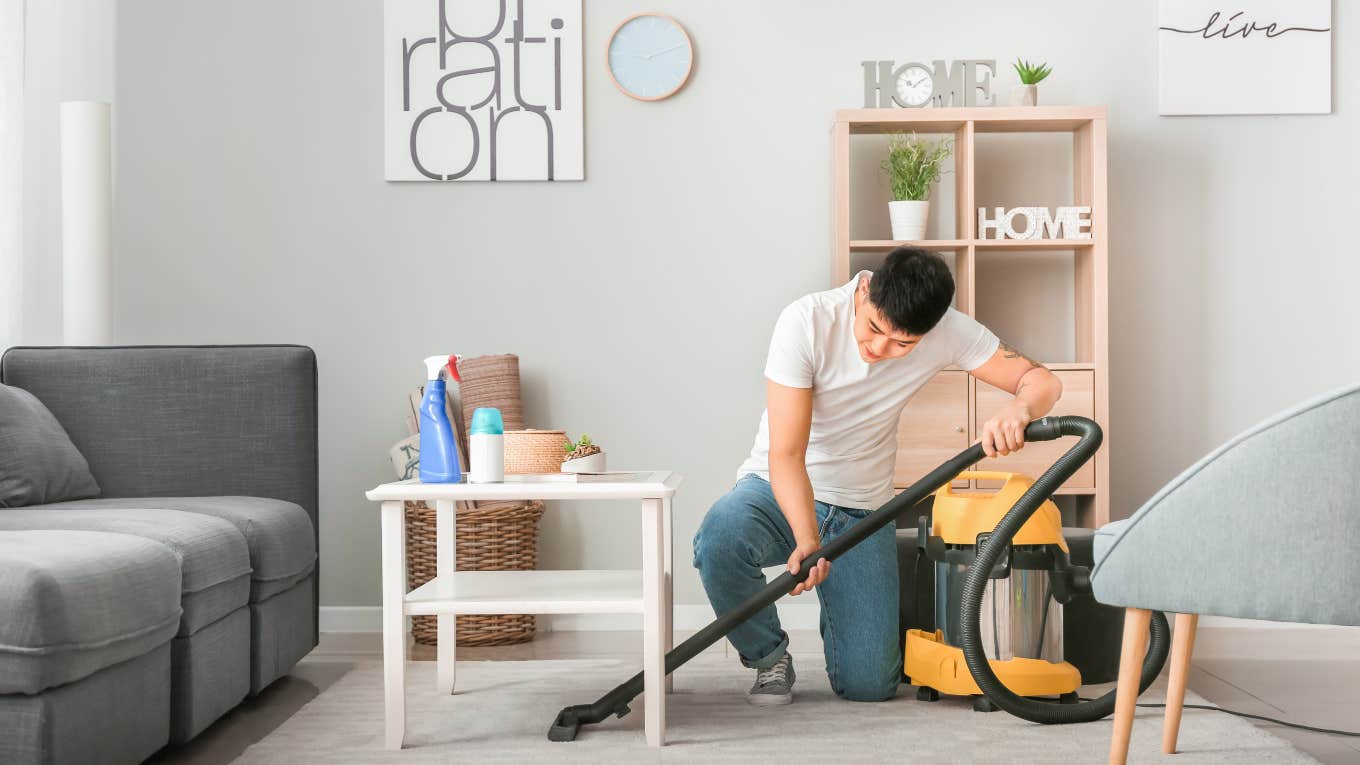 man vacuuming living room in his house