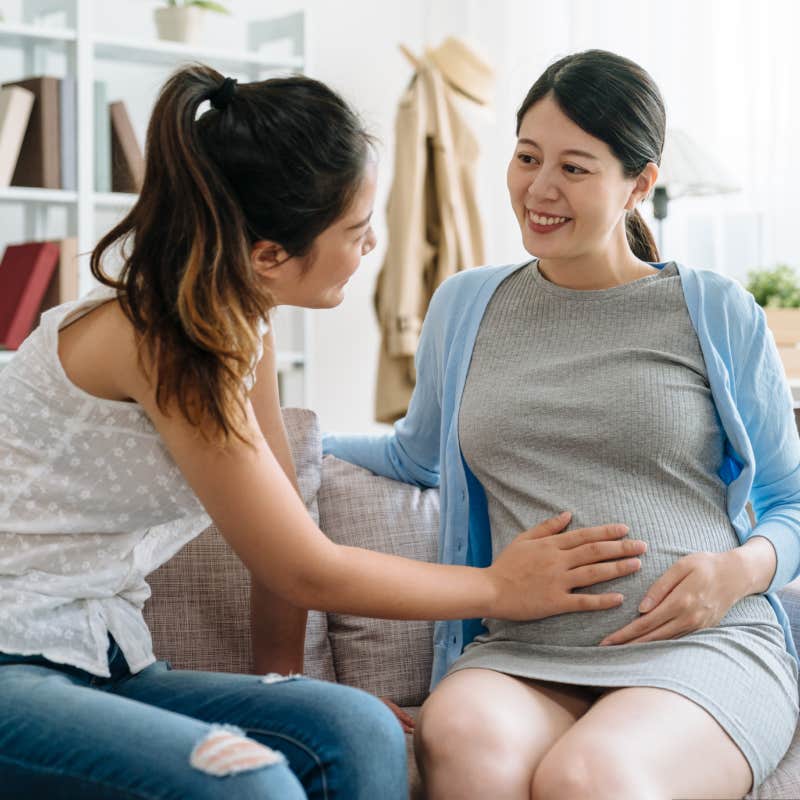 woman rubbing pregnant sister's belly