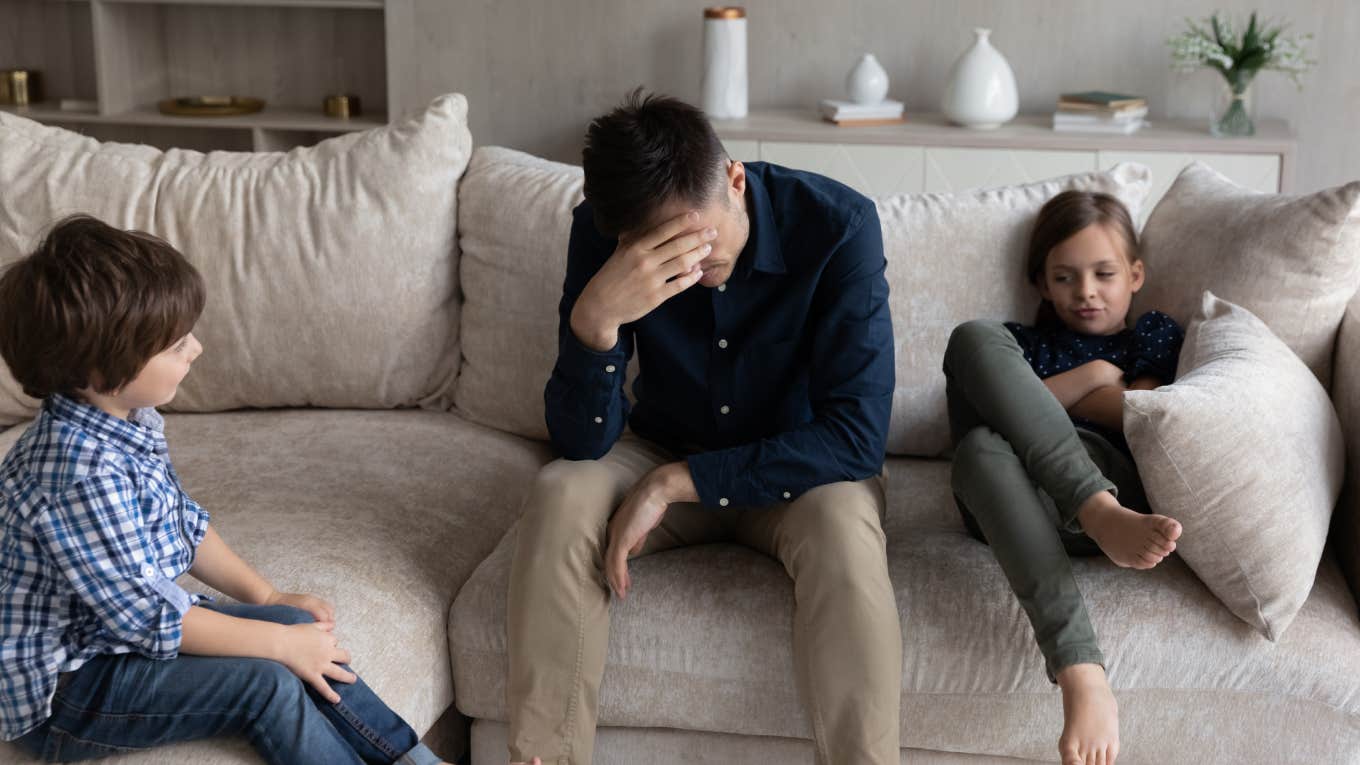 tired dad and bored kids sitting on couch