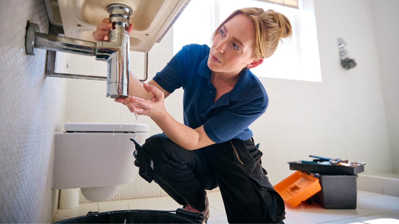 female plumber working on a sink