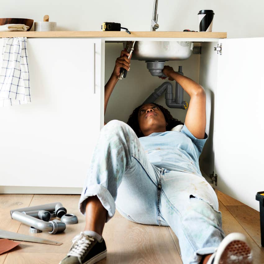 woman fixing a sink