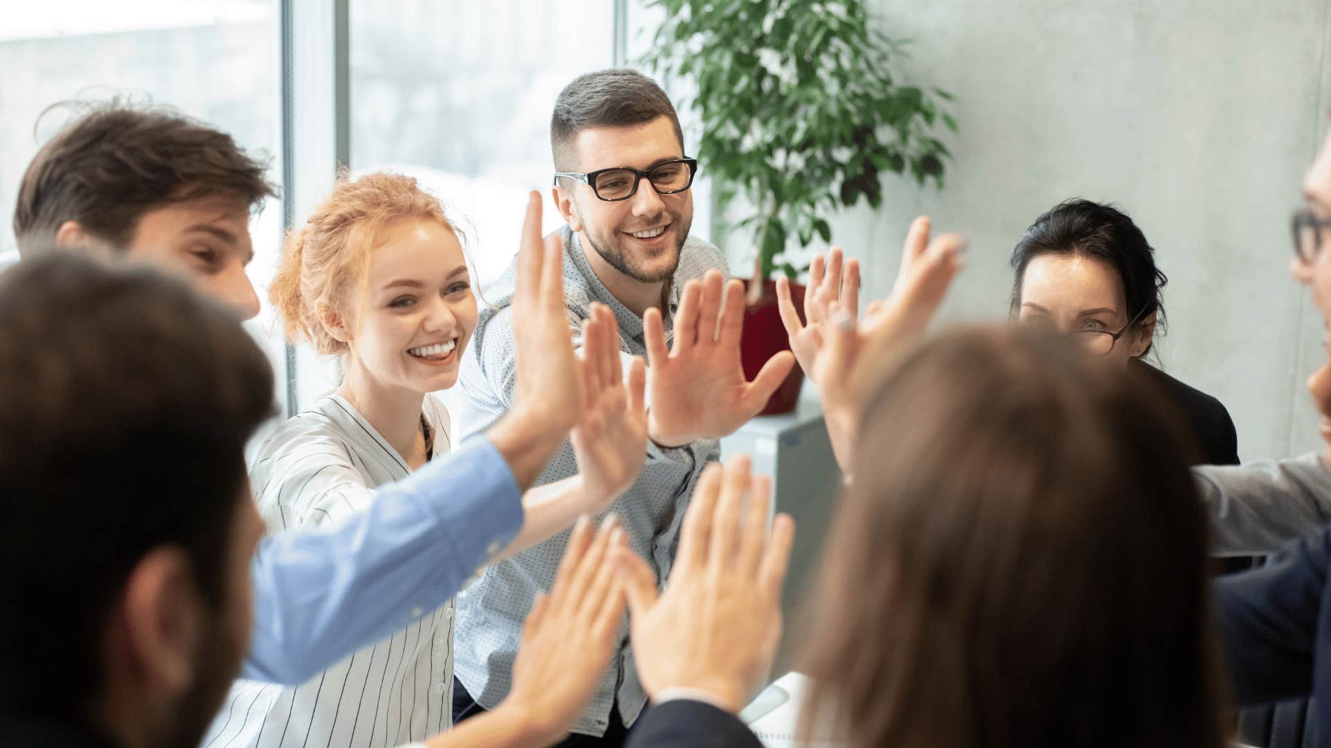 coworkers high fiving each other 