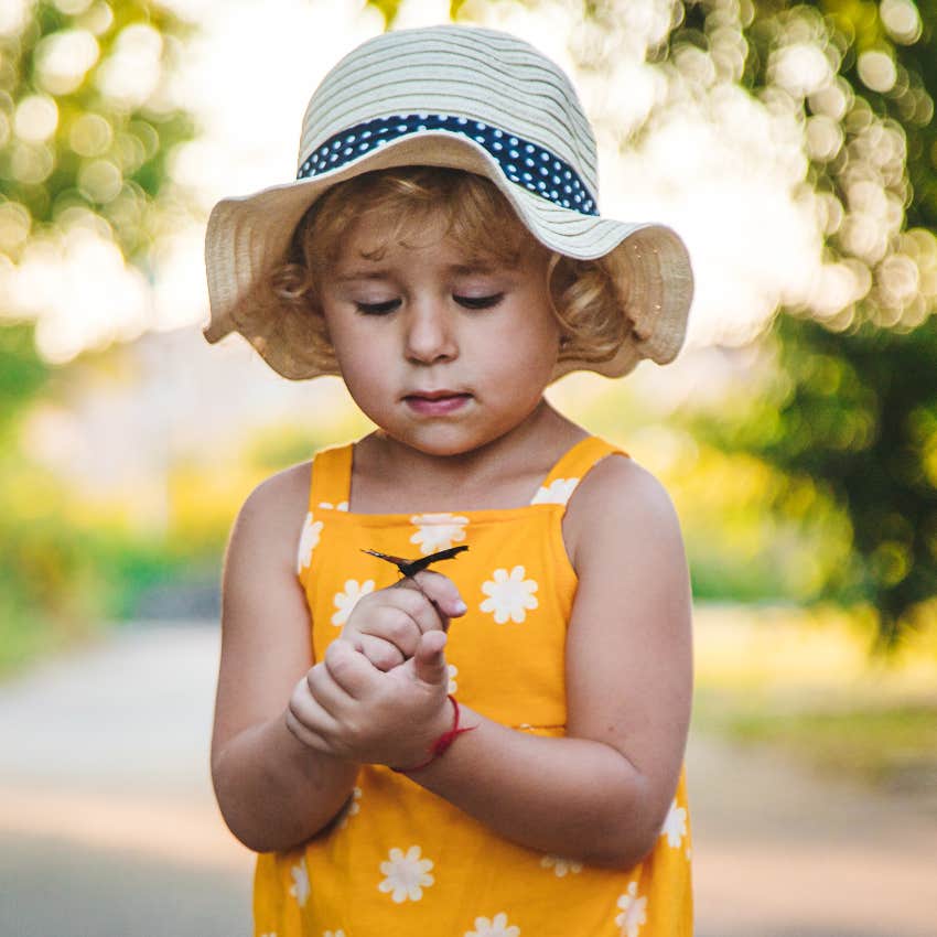 Little girl holding a butterfly she calls dada