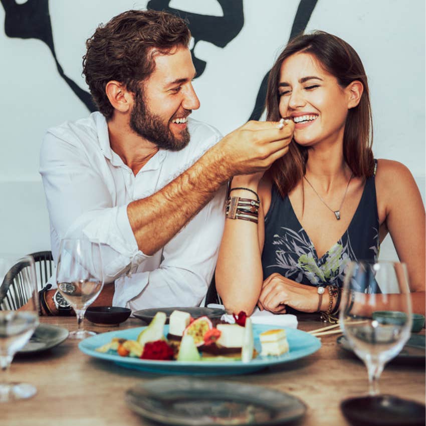 man feeding woman