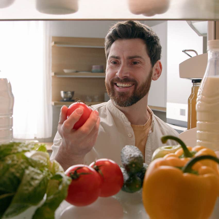 Man getting vegetable out of fridge