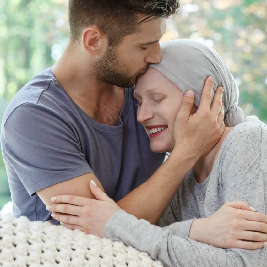 man kissing forehead of woman