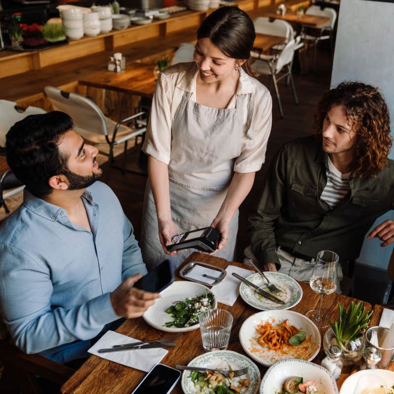 man using smartphone while paying restaurant bill 