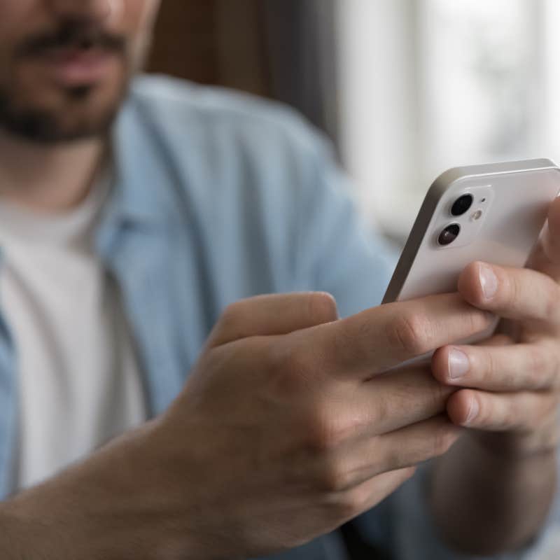 man sitting at table holding cellphone