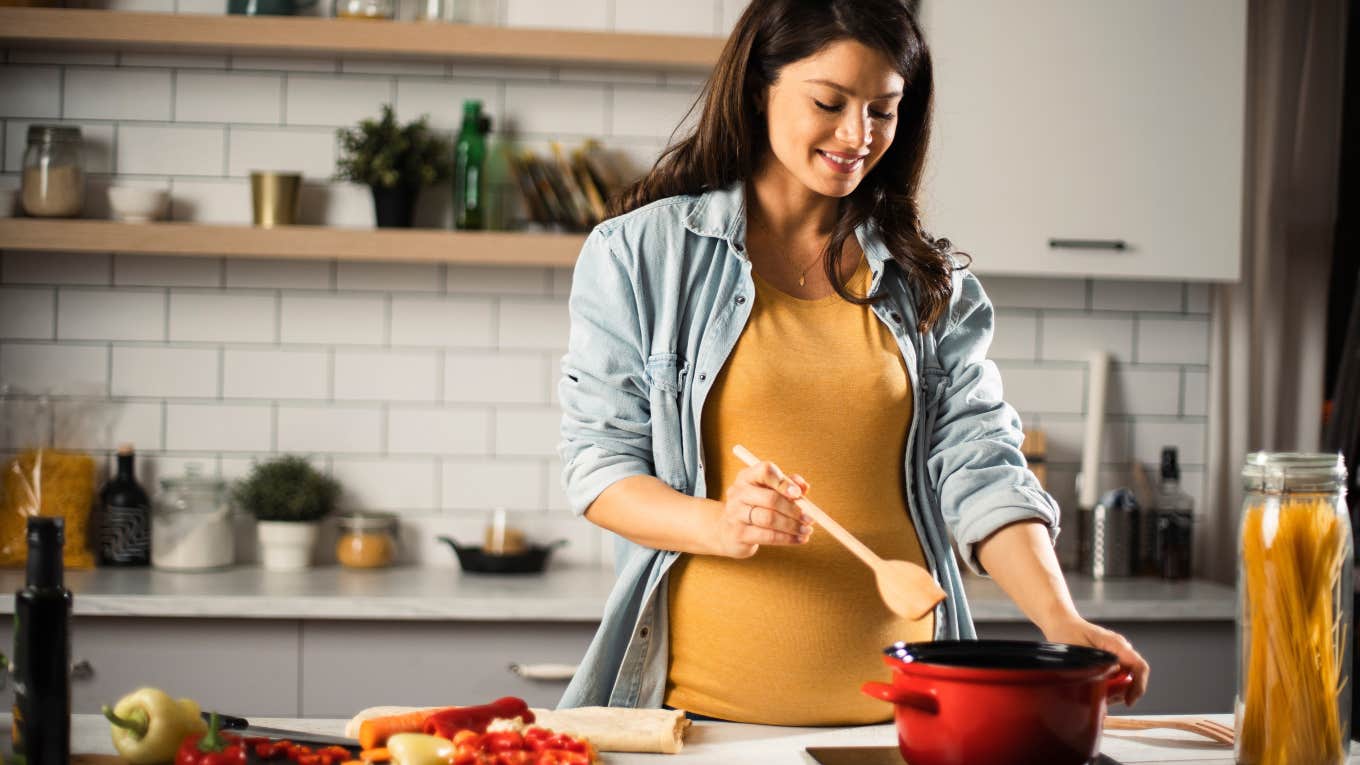 pregnant woman cooking in kitchen