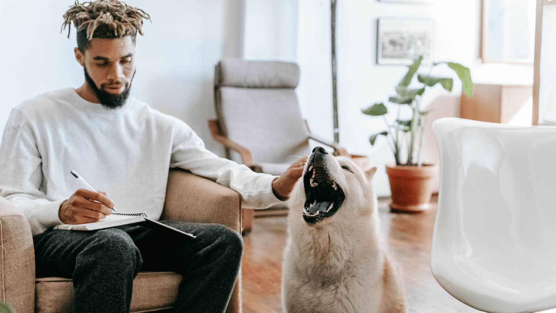 man expanding his brain power while petting dog