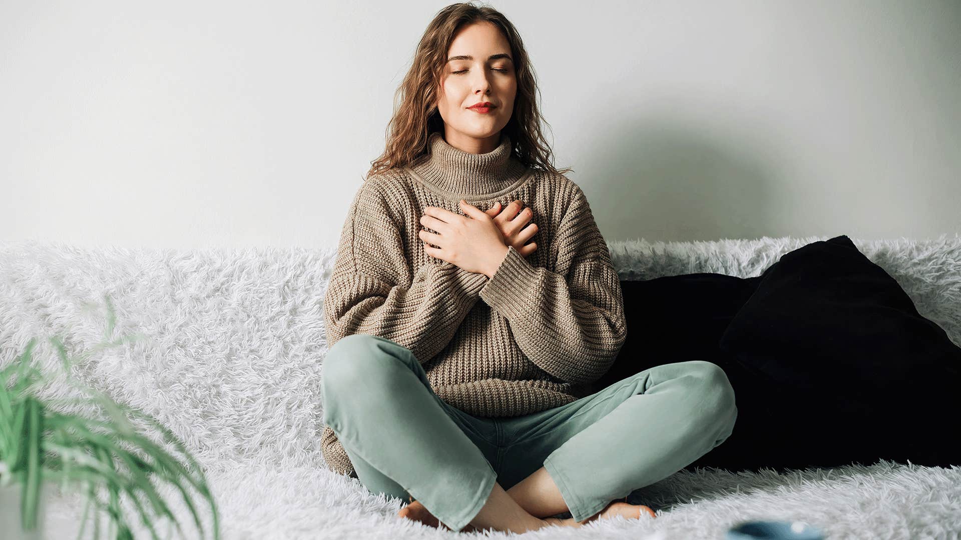 woman sitting on couch practicing mindful breathing