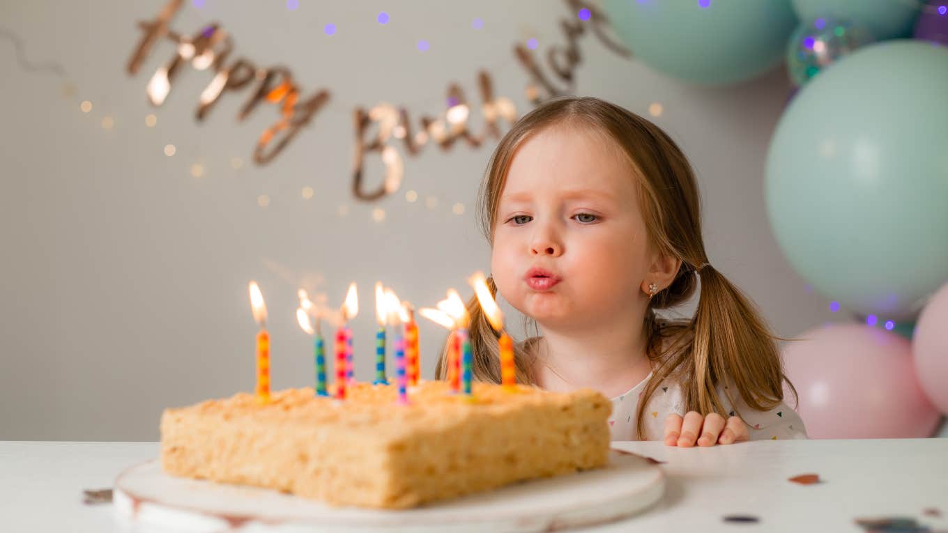 little girl blowing out birthday candles