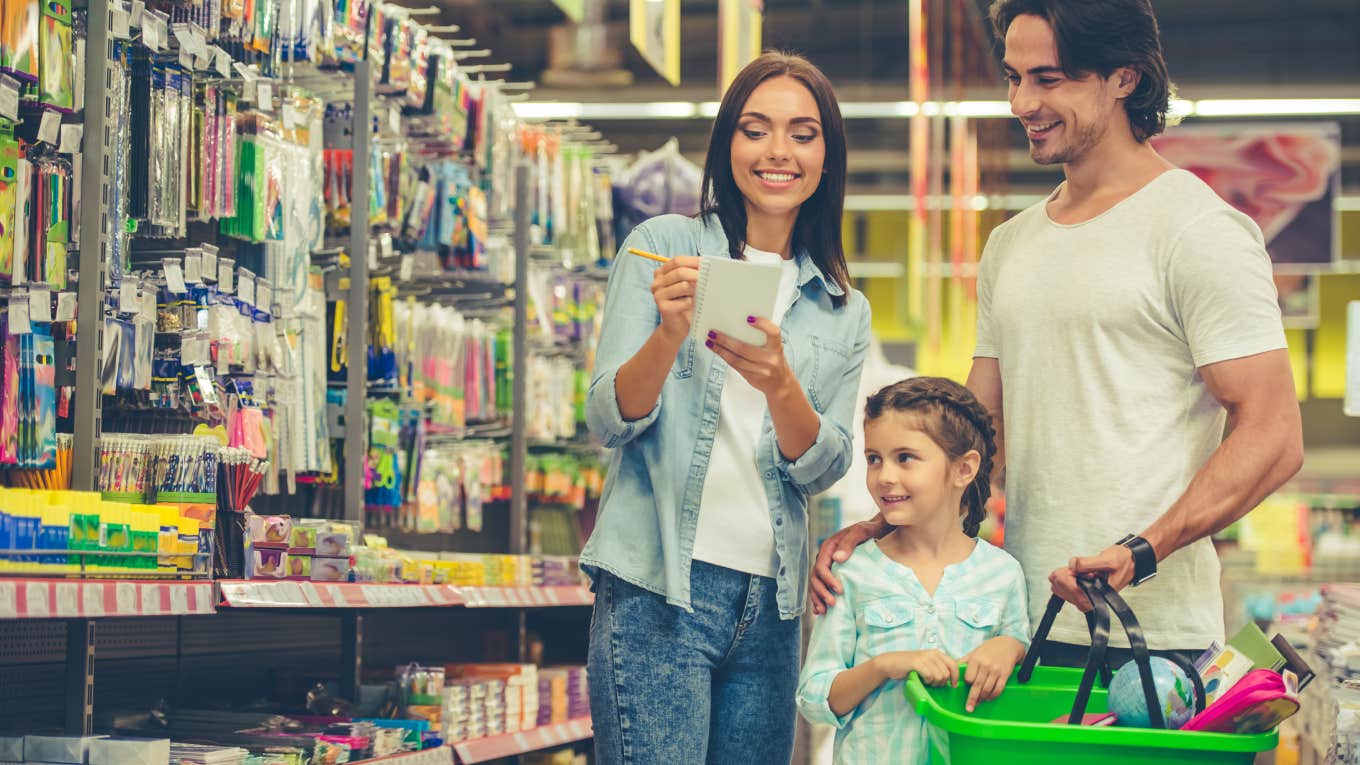 parents buying school supplies for child at store